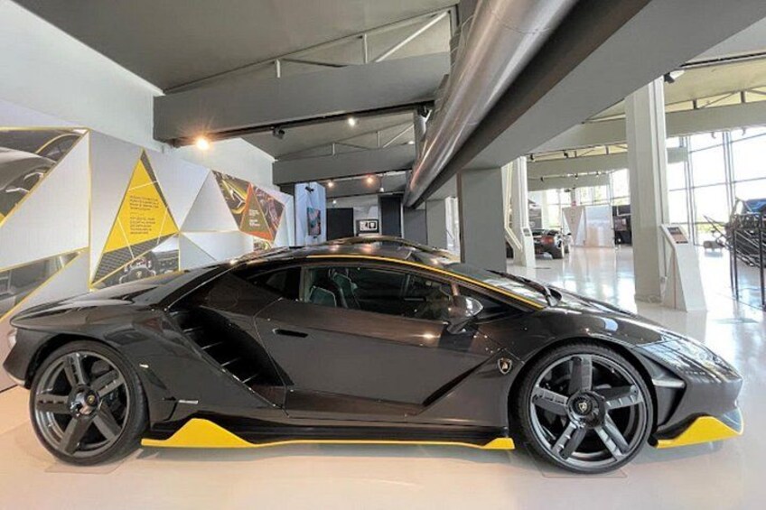 A black sports car with yellow accents in a showroom. 1