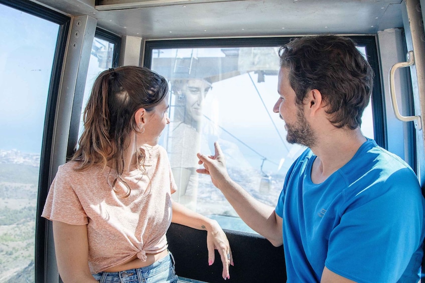 Two people conversing inside a vehicle with a view of a mountainous landscape. 5