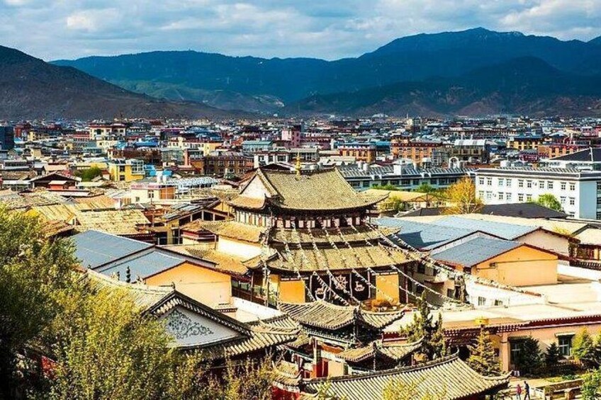 Un borgo tradizionale con edifici storici e montagne sullo sfondo. 5