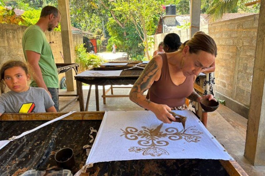 A person painting a design on a fabric. 4