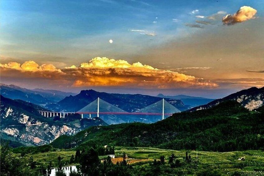 A suspension bridge, mountains, and a body of water. 2