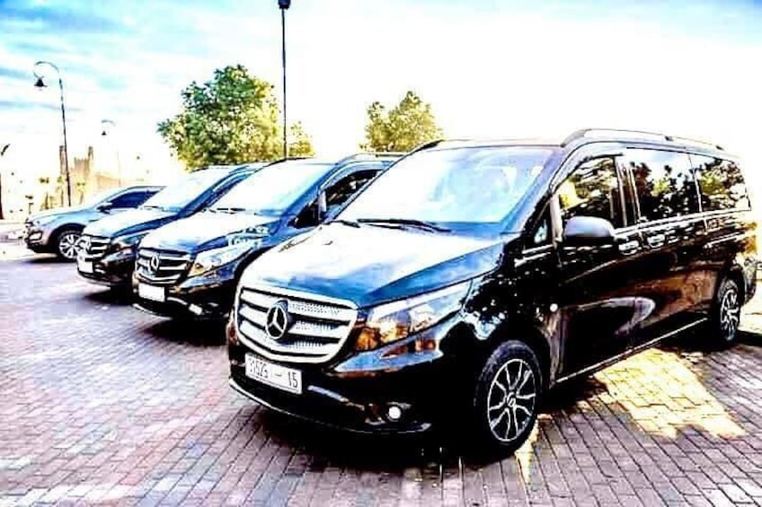 Una fila de furgonetas negras Mercedes-Benz estacionadas sobre un adoquín. 5