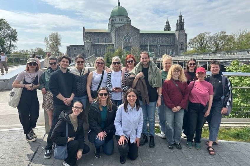 Un grupo de personas posando frente a un edificio histórico con una cúpula y torres. 4