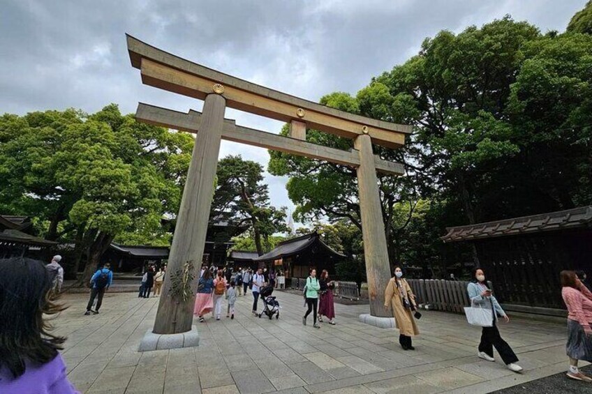A traditional Japanese torii gate in a park with people walking around. 2