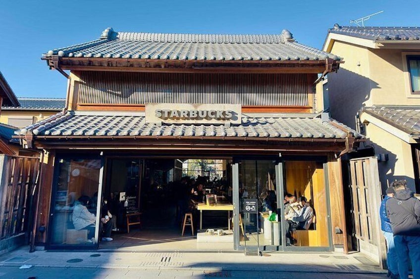Una Starbucks con un estilo arquitectónico tradicional japonés, que incluye un tejado de baldosas y fachada de madera. 3