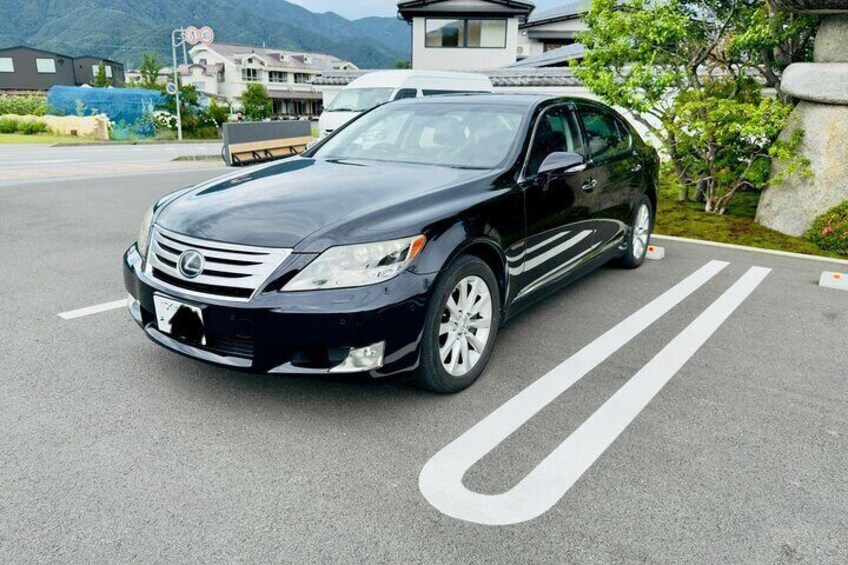 En sort Lexus parkeret på en parkeringsplads med hvide markeringer. 2