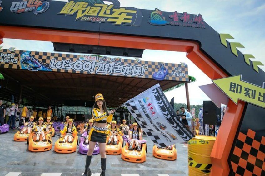 A racing theme entrance with a speed car sign, a checkered flag, and a woman holding a sign. 3
