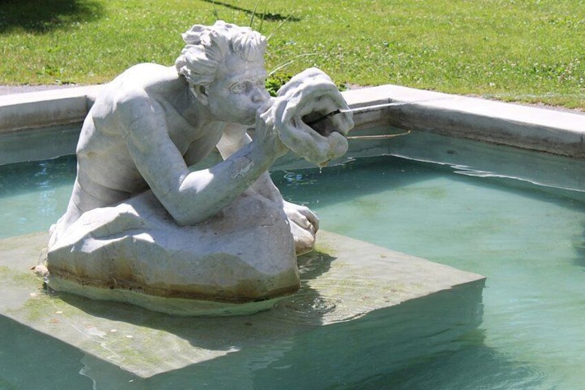 Una estatua de un hombre sentado junto a una piscina. 3