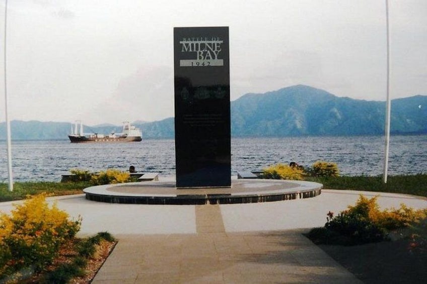 Una placa conmemorativa con un barco al fondo. 1