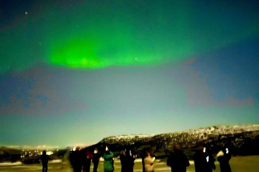 A group of people observing the Northern Lights. 3