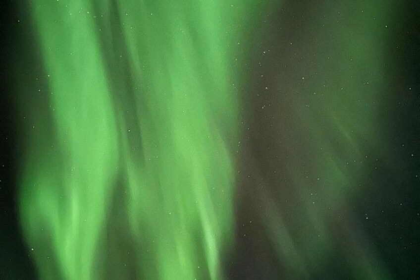 The aurora borealis with green hues and visible stars. 2