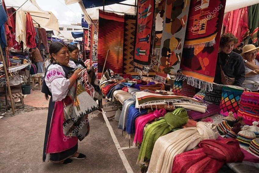A market with colorful textiles and a person examining a woven item. 4