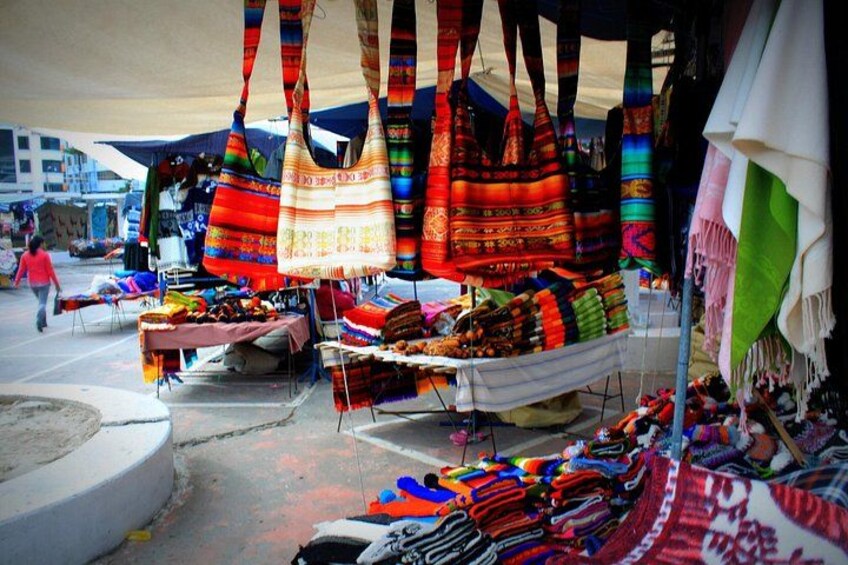 A market stall with colorful bags and textiles. 3