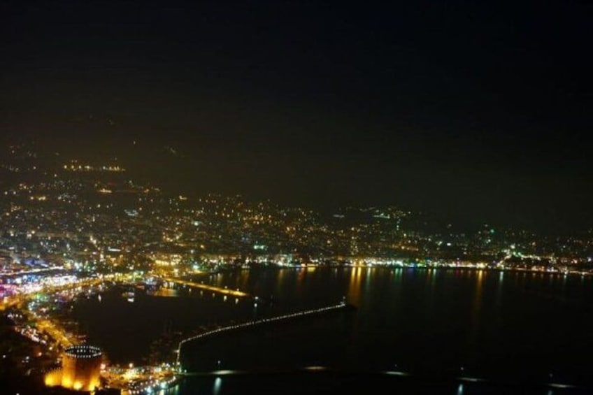 A nighttime cityscape with a river and a bridge. 2