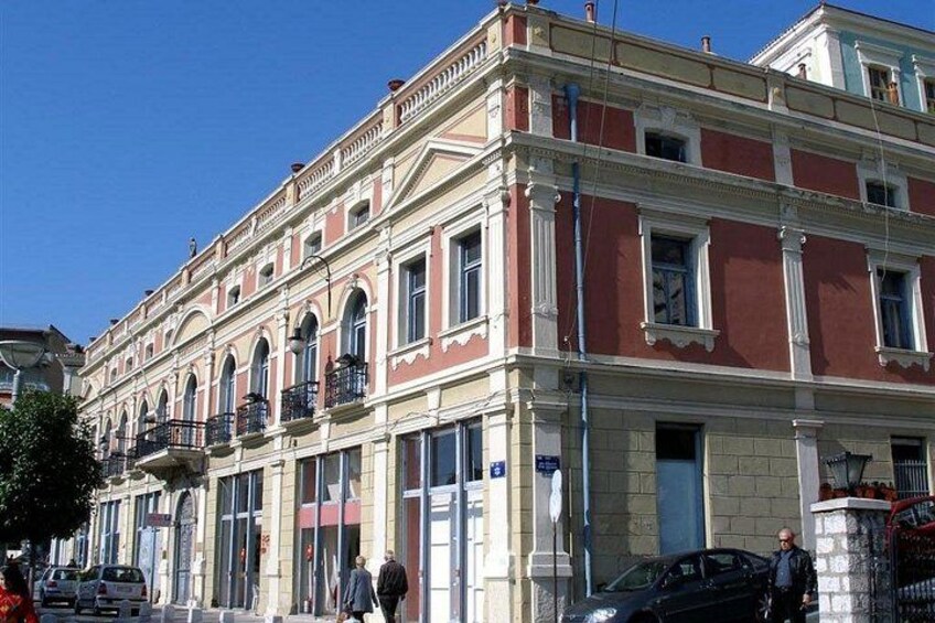 A multi-story building with classical architecture, including columns and arched windows. 4