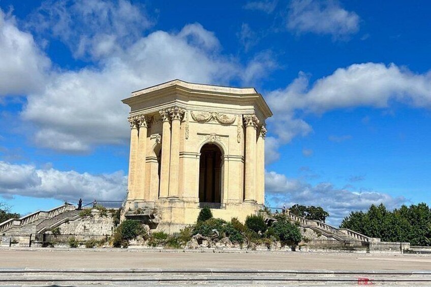A large neoclassical monument with a central archway, surrounded by a wide plaza and a staircase leading up to it. 2