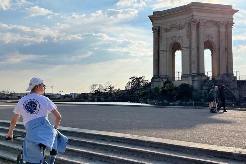 A person on a bicycle, a large historical monument, and a clear sky. 3