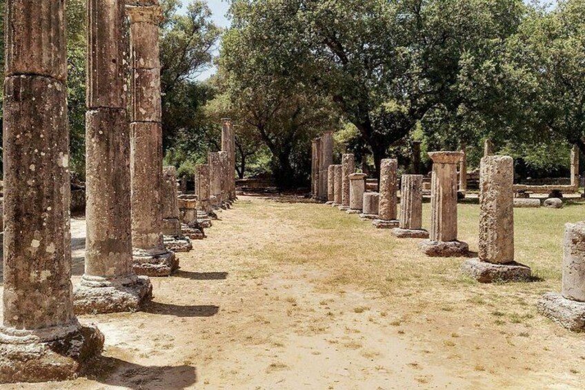 Ancient stone columns in a row, surrounded by trees. 3