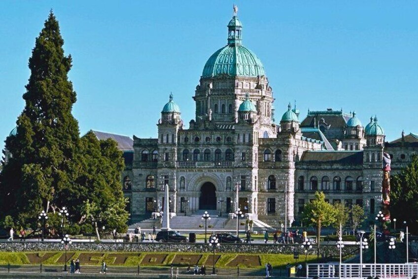 A large, historic building with a prominent dome and multiple smaller domes, surrounded by a well-maintained park with trees and pathways. 2