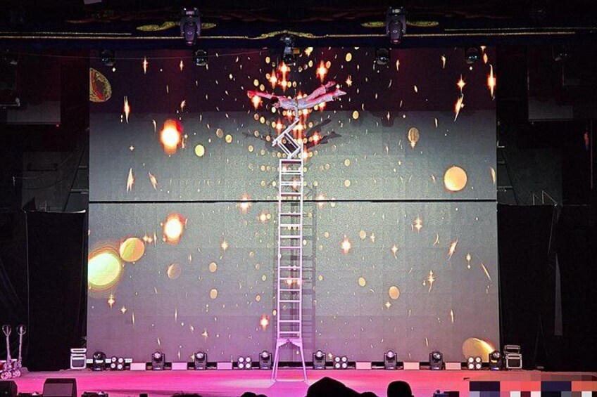 A stage with a ladder, spotlights, and a dark background with light effects. 3