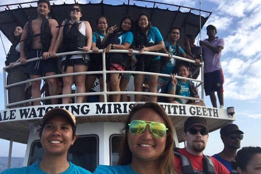 A group of people on a boat with a sign that reads 'WALKING MIRIS WITH GEETH'. 4