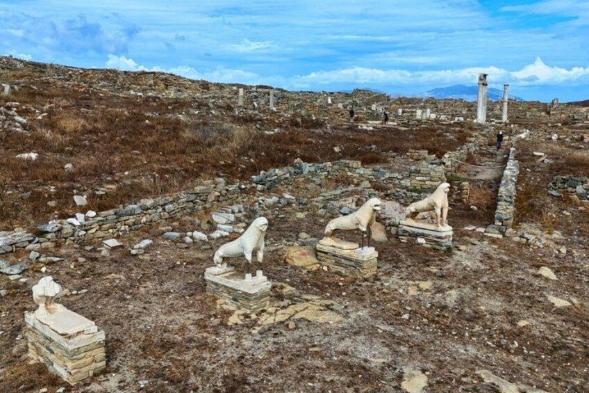 Ancient ruins with stone statues of lions and columns. 5