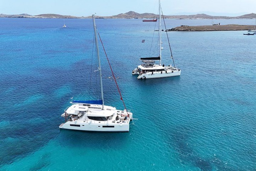 A clear blue sea with two sailboats anchored. 4