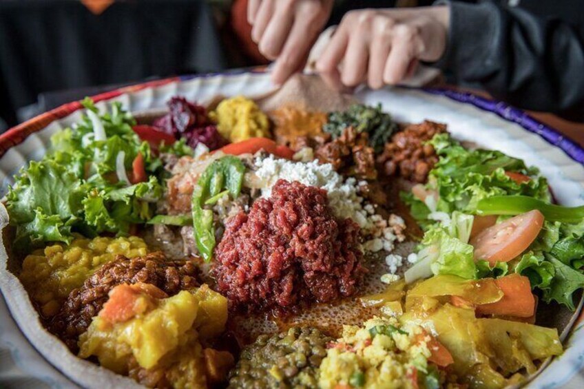Een groot schaalbord met diverse gerechten, waaronder salades, vlees en groenten. 1
