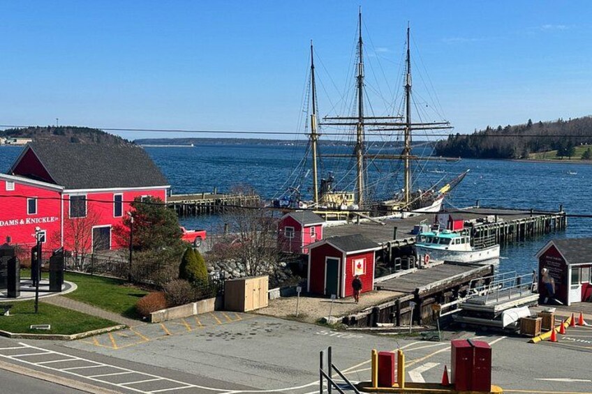 A red building, a dock, a large ship, and a body of water. 4