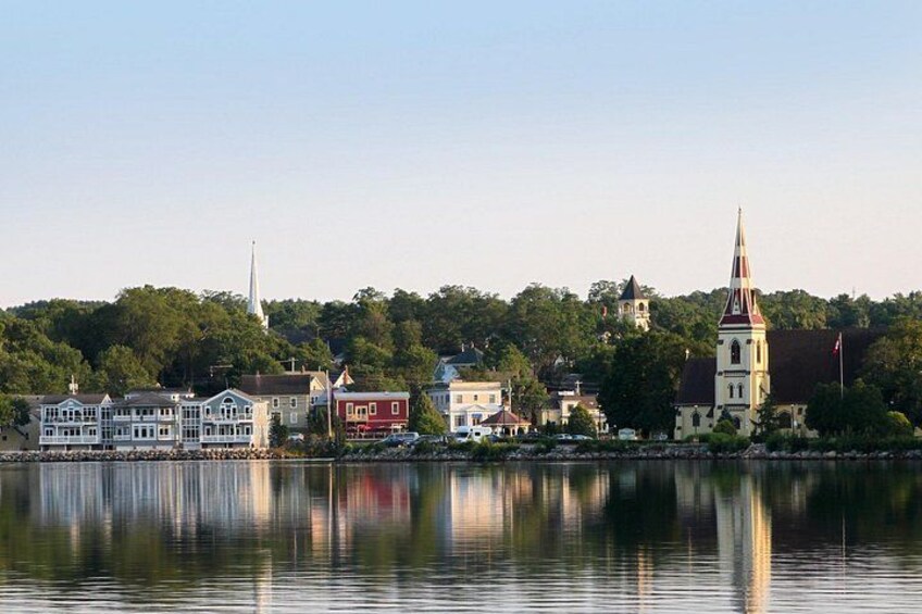 A calm lake with buildings and a church on the shore. 5