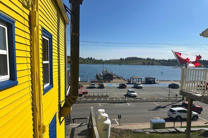 A yellow building with a dock, a parking lot, and a body of water in the background. 3