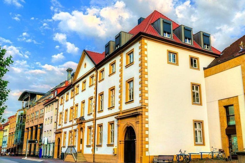 A row of historic buildings with red roofs and yellow window frames. 3