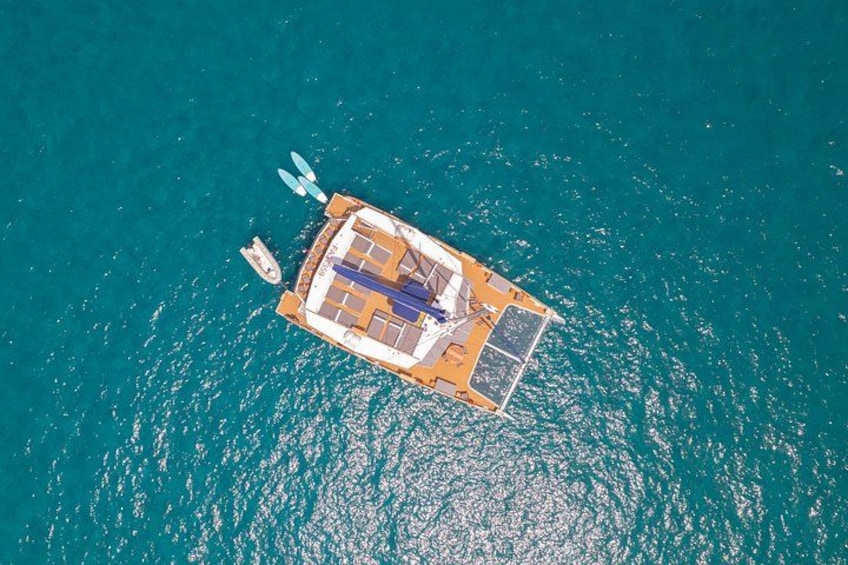 An aerial view of a floating platform with a boat docked at its edge, surrounded by turquoise water. 2
