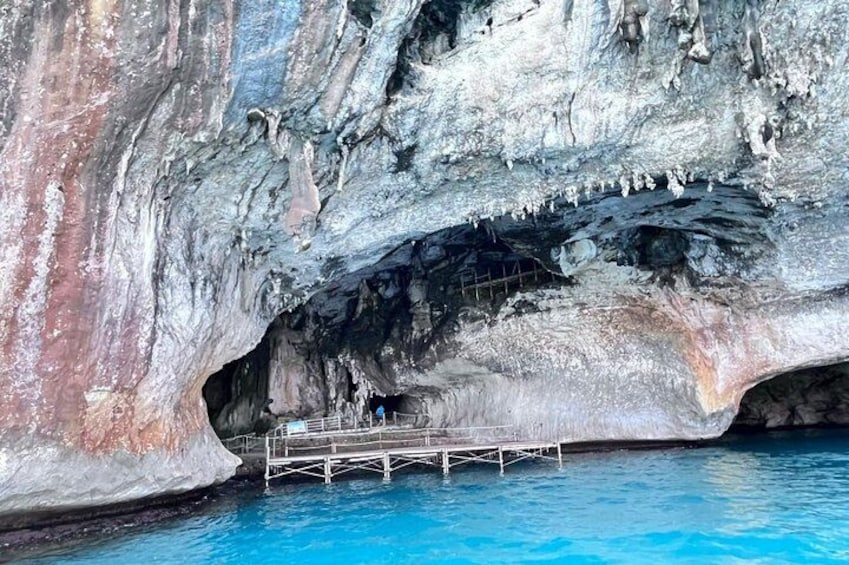 A cave with stalactites and a pool of water at the bottom. 5