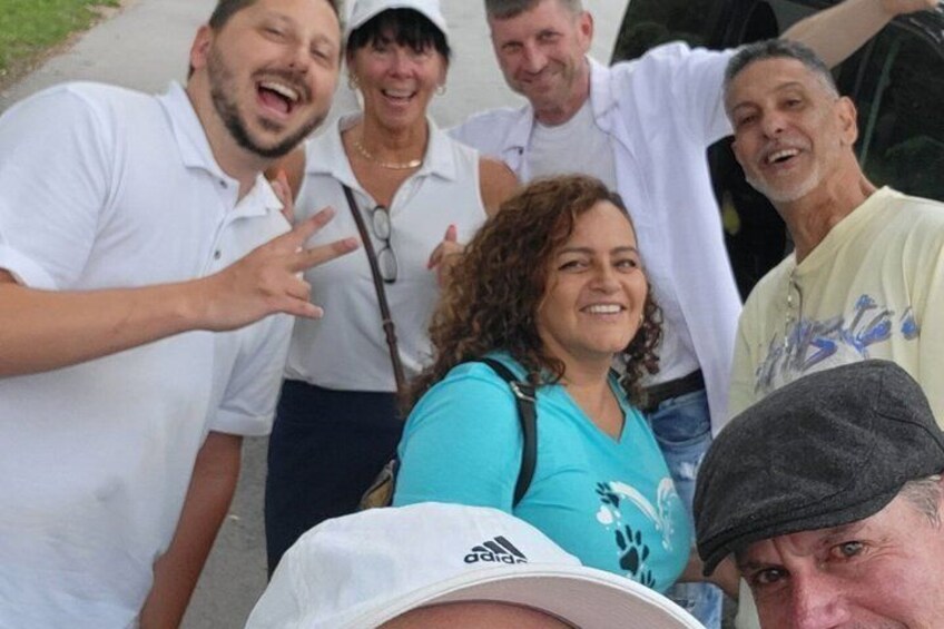Un grupo de personas al aire libre, algunas con ropa informal y una con gorra blanca. 2