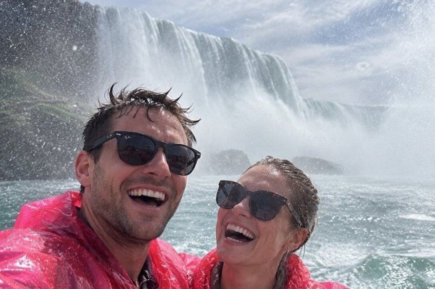 Una persona con una chaqueta roja en un bote, con una cascada al fondo. 1