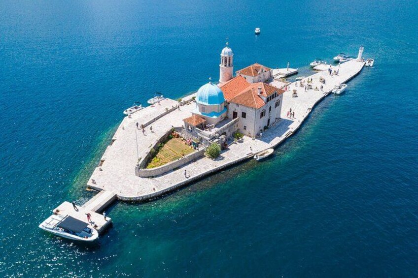 Luchtbeeld van een kustplaatsje met een opvallende kerk, een vuurtoren en een pier die in zee uitsteekt. 3