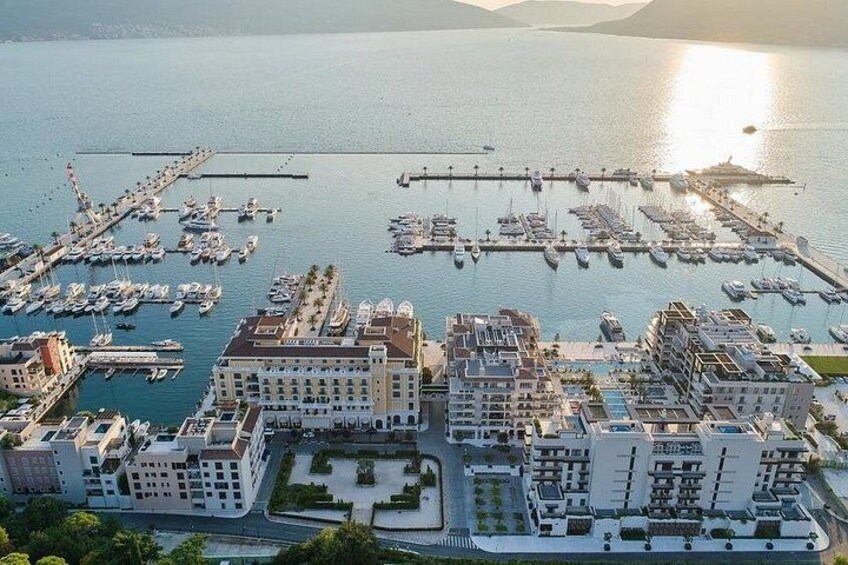 A marina with boats, buildings, and a sunset. 3