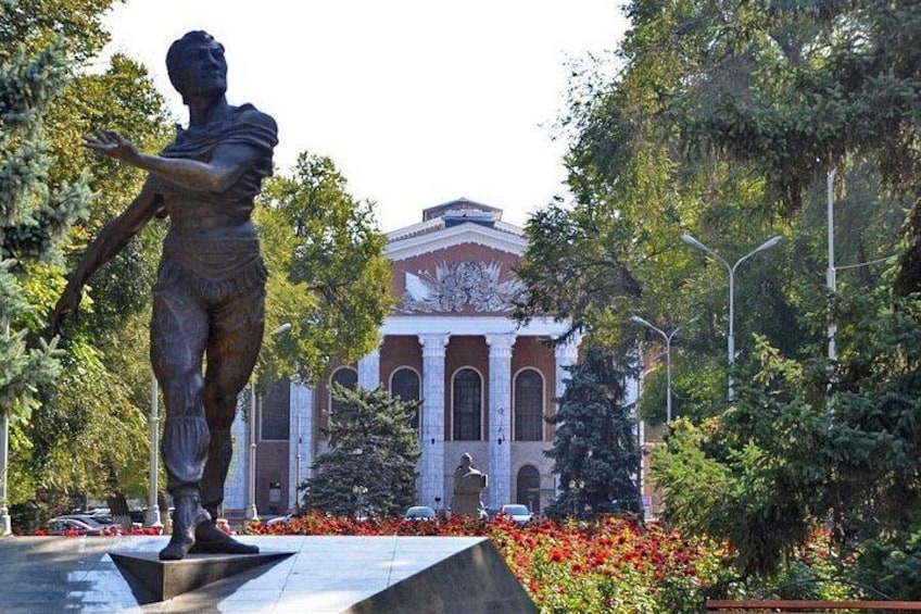 A statue in a park with a building in the background. 4