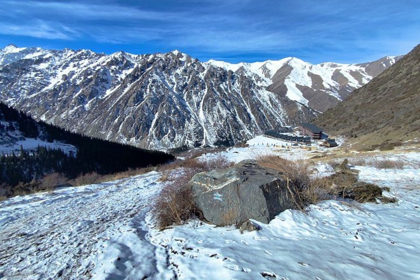 A snow-covered mountainous landscape with a building nestled among the peaks. 2