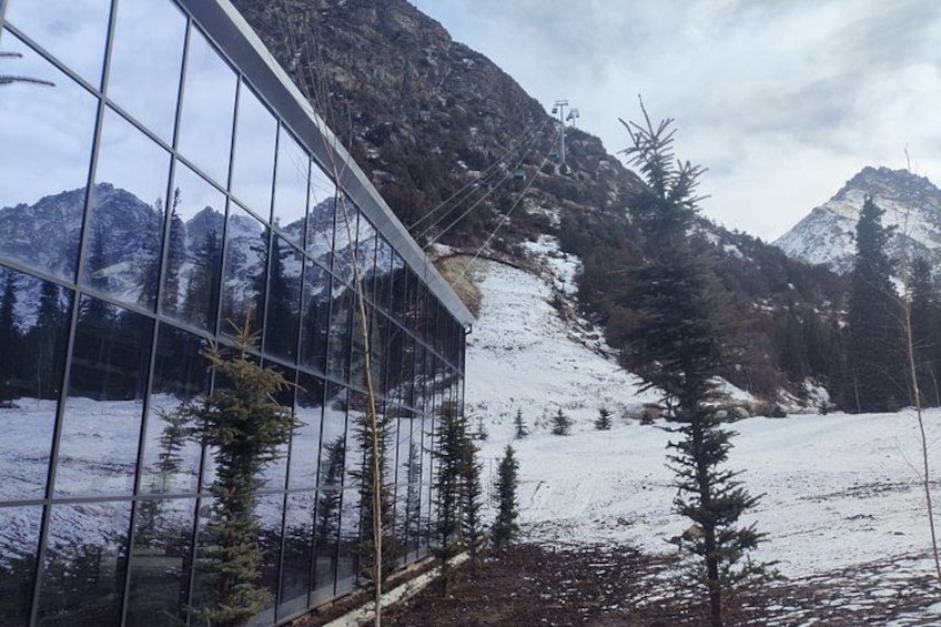 A snowy mountain landscape with a glass building reflecting the scenery. 4