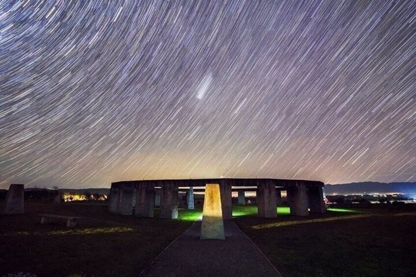A stone structure with a central light source, surrounded by a starry night sky. 4