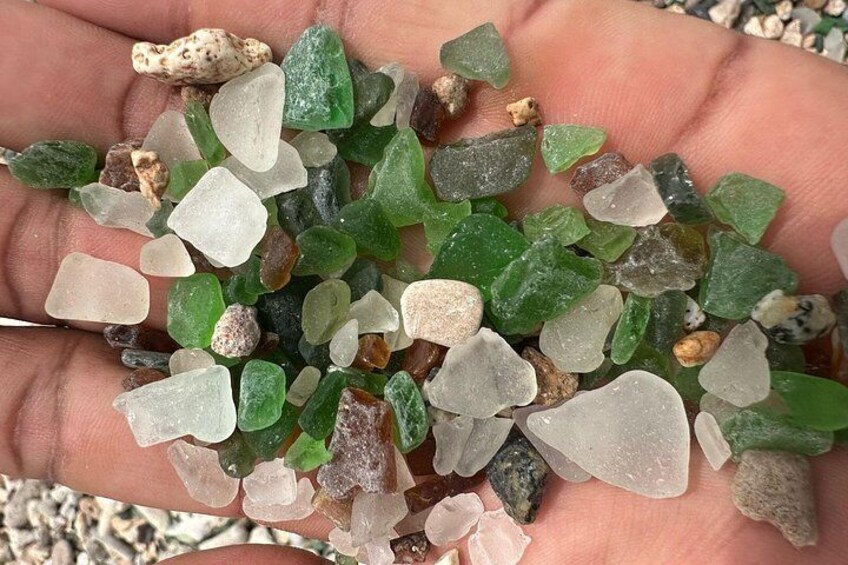 A hand holding variously colored and shaped glass pebbles. 5