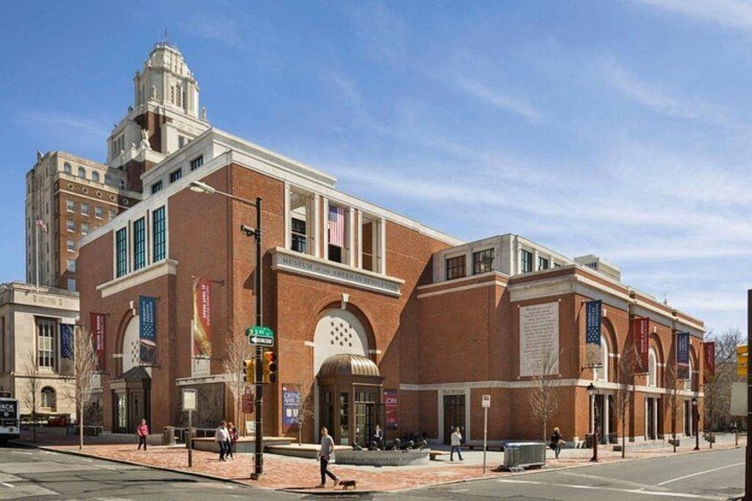 A historic building with a clock tower, large windows, and a red brick facade. 4