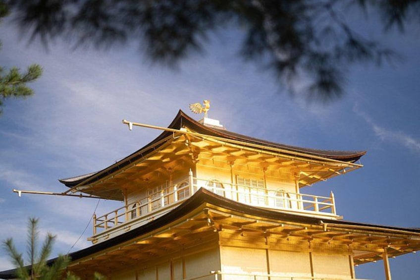 A traditional Japanese pagoda with a golden roof, surrounded by trees. 2