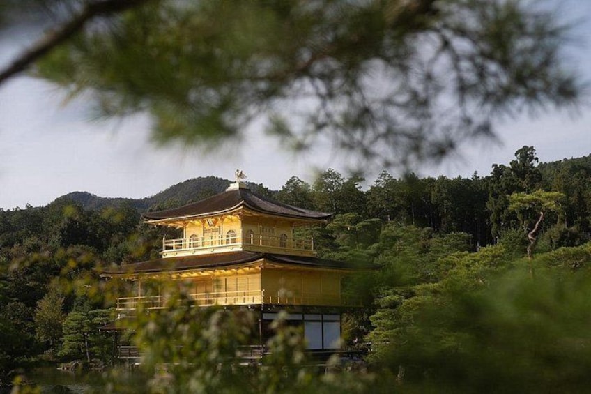 A traditional Japanese temple with a multi-tiered roof, surrounded by lush greenery and hills. 4
