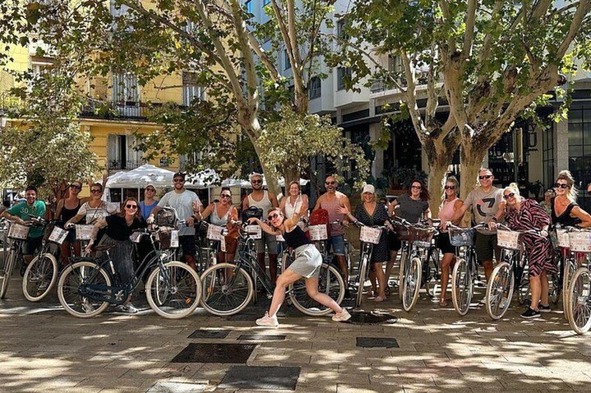 A group of people on bicycles in an outdoor setting with trees and buildings in the background. 5