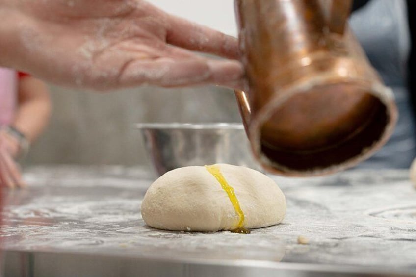 Putting virgin oil on the dough. 3