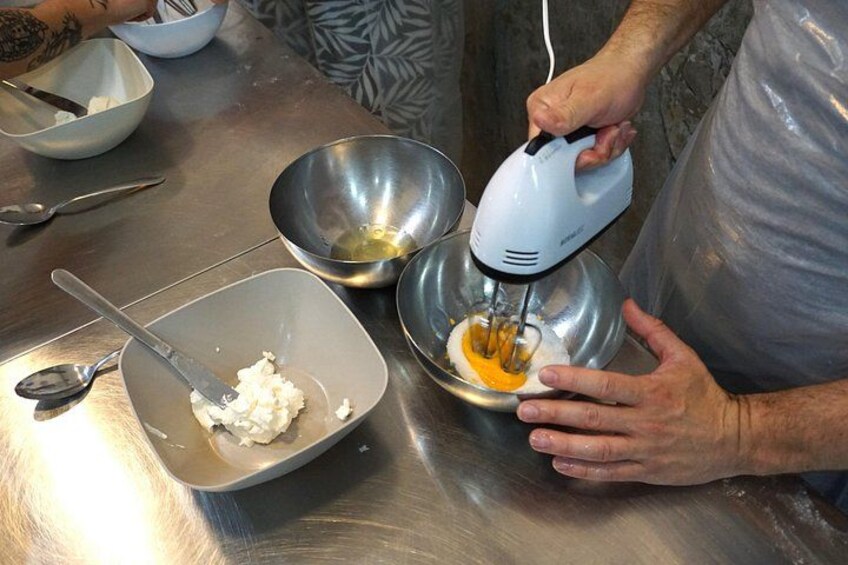 Mixing eggs to prepare the cream. 3