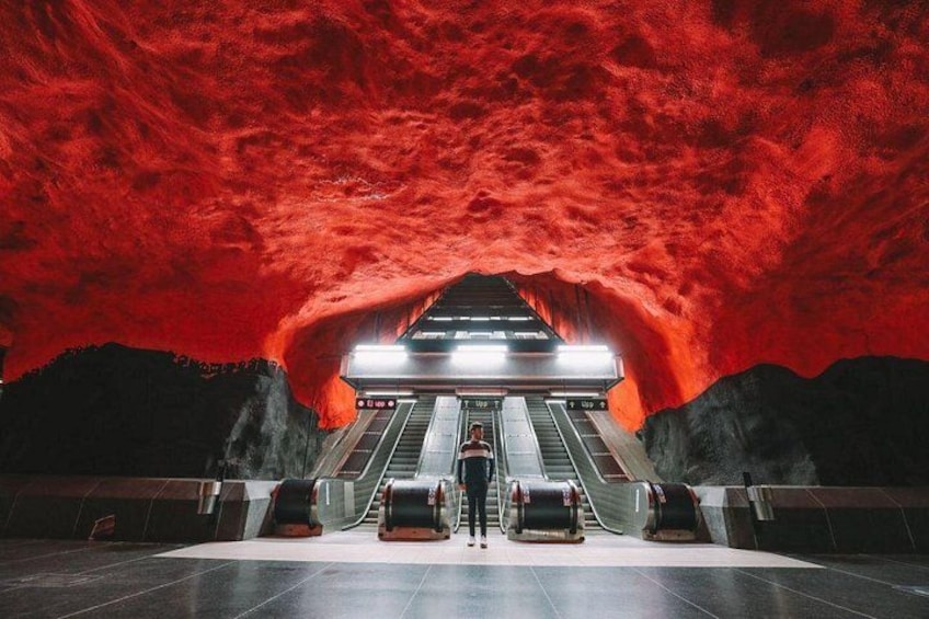 Une station de métro dotée d’escalators et d’un plafond rouge. 5